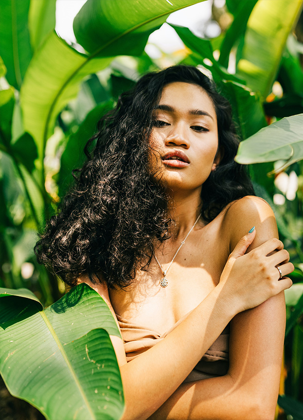 Woman Standing Between Green Leaves