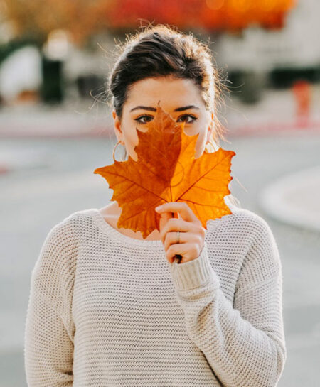 Woman Holding Maple Leaf in Front of her Face