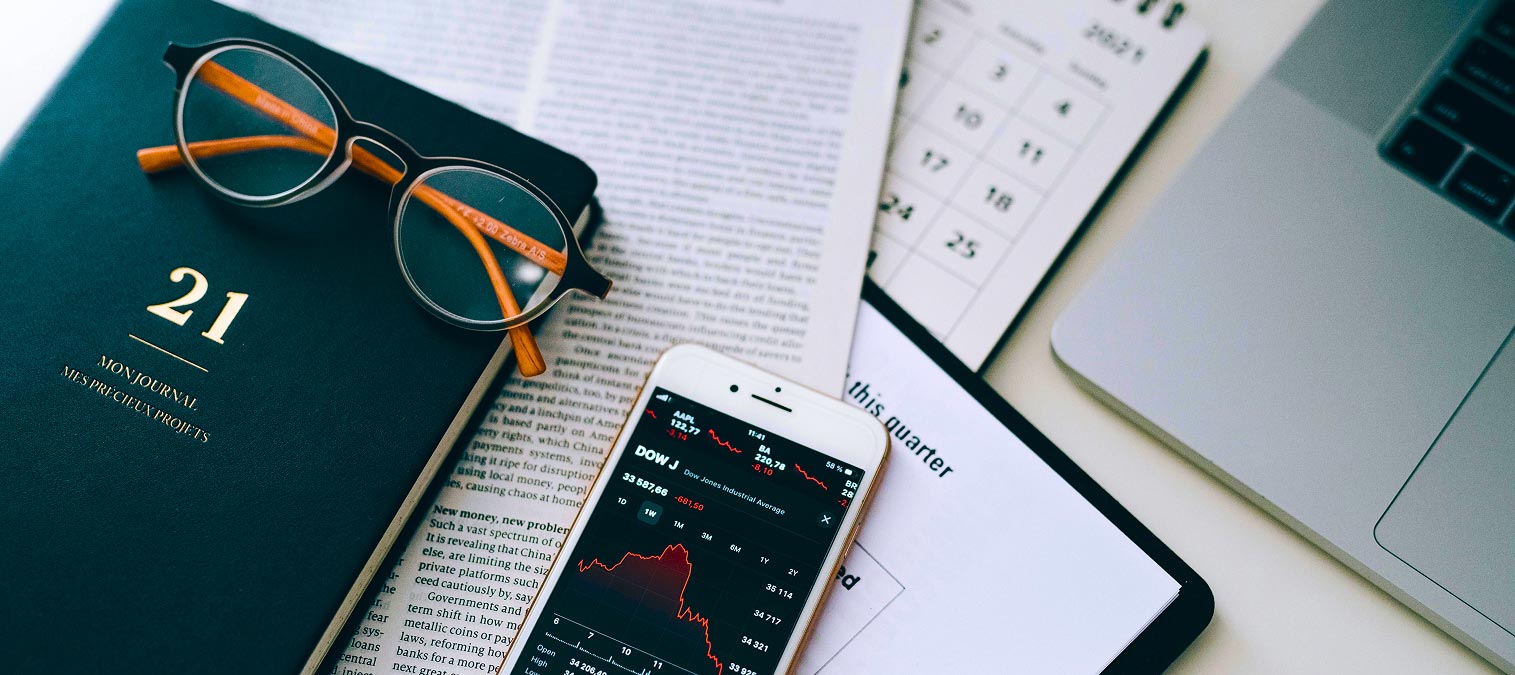 https://www.pexels.com/photo/smartphone-displaying-a-stock-market-chart-lying-on-documents-next-to-a-laptop-on-the-desk-7887850